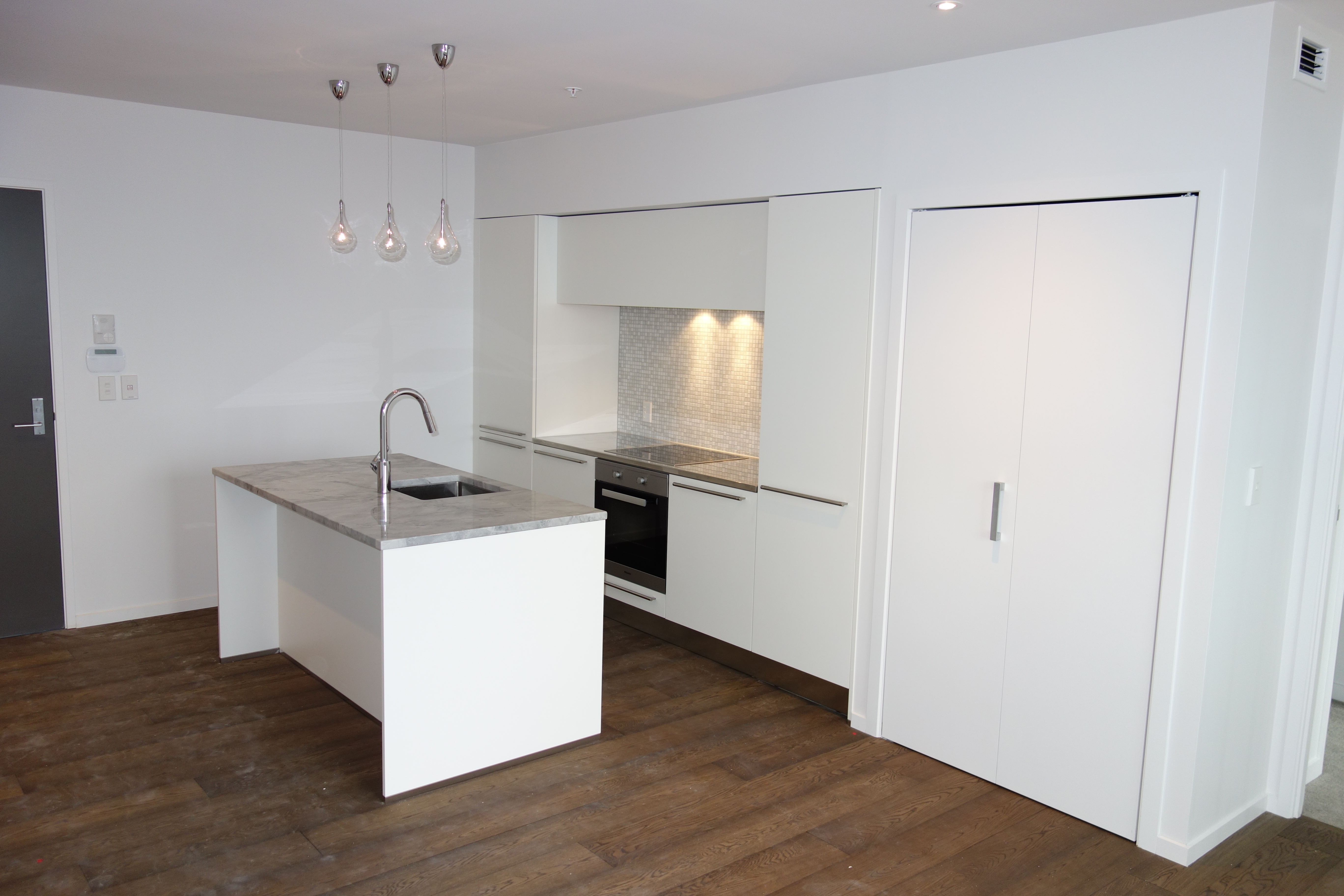White kitchen with timber flooring by OnsiteJoiner